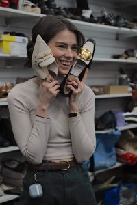 Courtney holding shoes at Mr Fixit, a Bowral shoe repair shop in Springett’s Arcade.