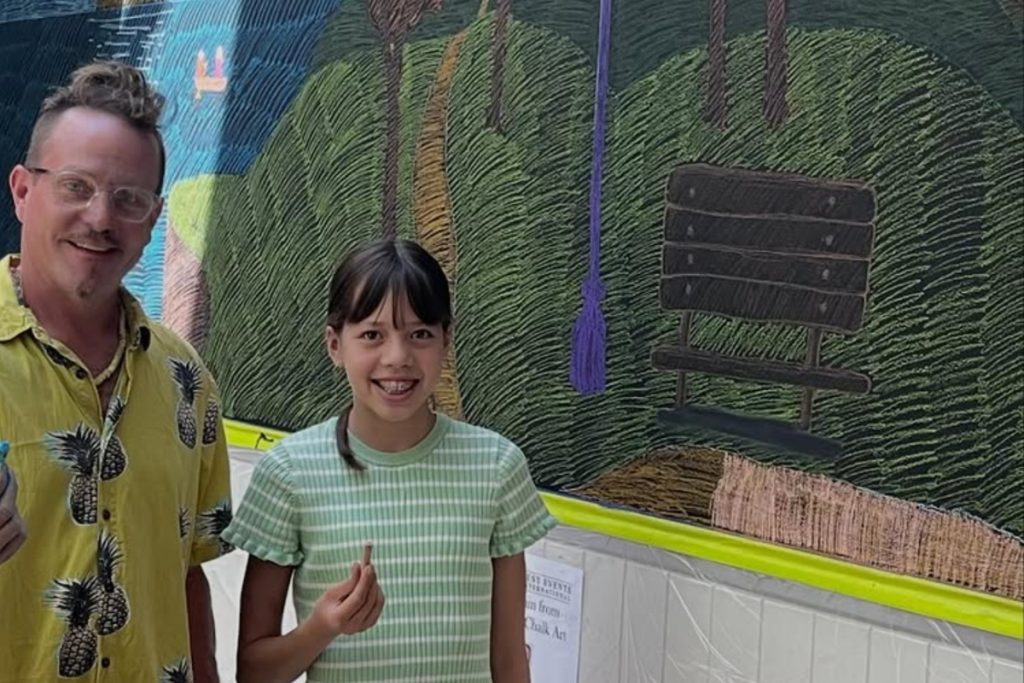 Professional chalk artist Rudy Kistler and Grand Prize winner Nevaeh Dewhurst from Mittagong Public School standing in front of the Be Part of the Art chalk mural at Springett’s Arcade.
