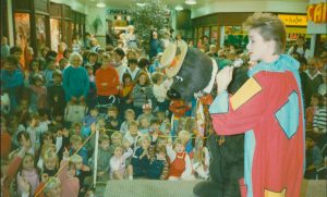 Families gather for a community event featuring Humphrey B Bear at Springett's Arcade.